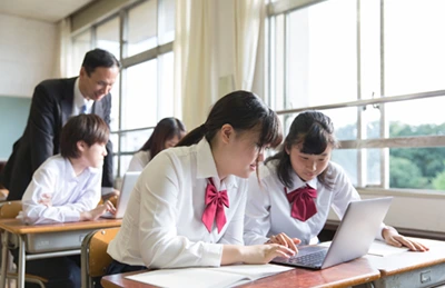 タブレットを使って学ぶ生徒と指導する教員