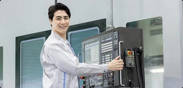 製造現場で工作機械を操作するスタッフ